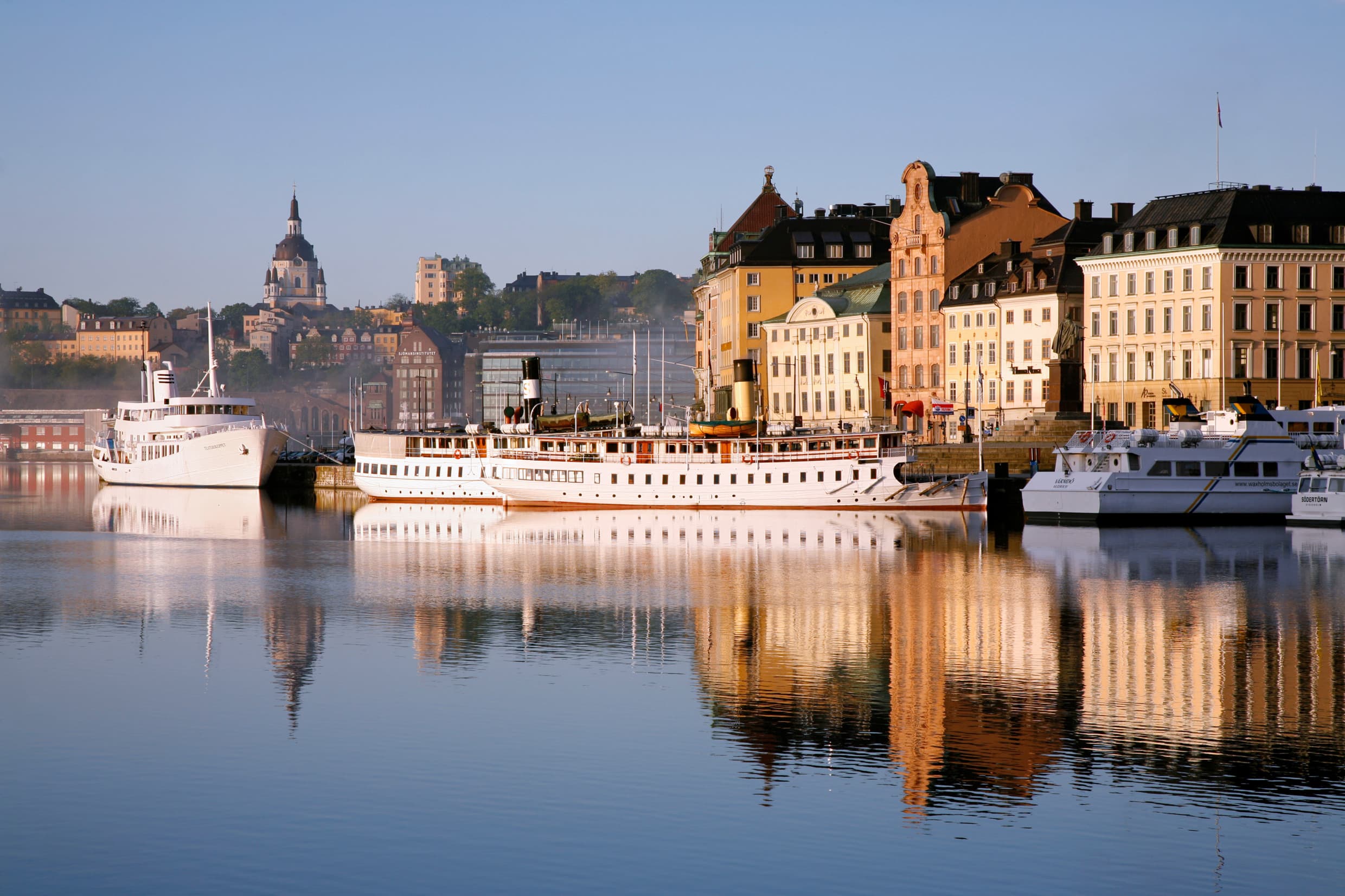 Historic waterfront buildings and boats along Skeppsbron in Stockholm